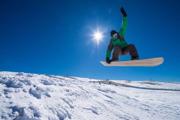 istock Snowboarder jumping against blue sky 893966142
