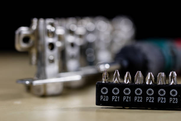 istock Carpentry tools and accessories on a workshop table. Hinges and screws together with the screwdriver in the workshop. Black background. 893985900