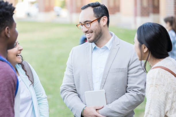 istock Male teacher or principal talks with group of students 893988448