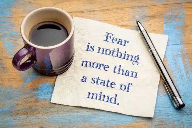 Fear is nothing more than a state of mind - inspirational handwriting on a napkin with a cup of espresso coffee