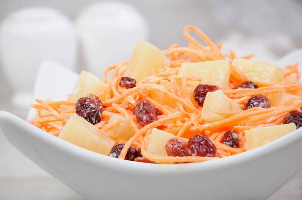 a salad of pineapple, fresh carrots, dried cranberries, yogurt dressed. Gluten free  vegan . stock photo