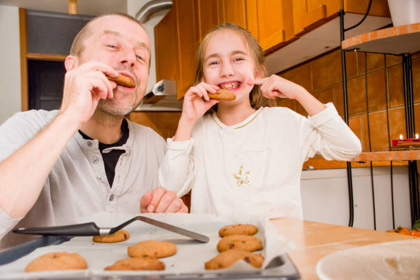 istock Father and Elementary Aged Girl Tasting a Home Made Cookies Together 894037204