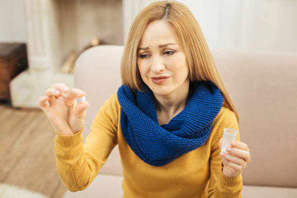 istock Ill young woman taking pills with disgust 894037326