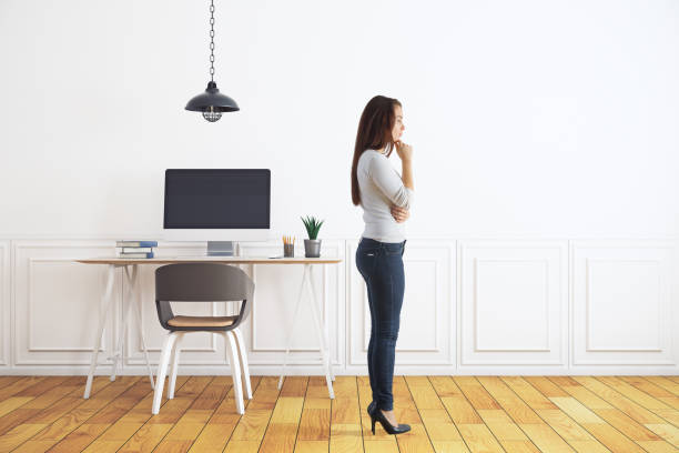 istock Thoughtful woman in room with workplace 894060770