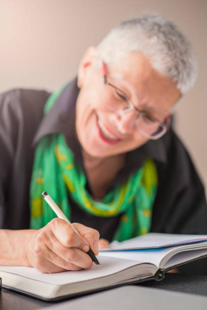 istock Journal or diary entry by a senior citizen woman 894074136