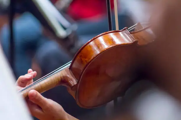 Photo of Symphonic orchestra playing violin in performing concert show on a stage