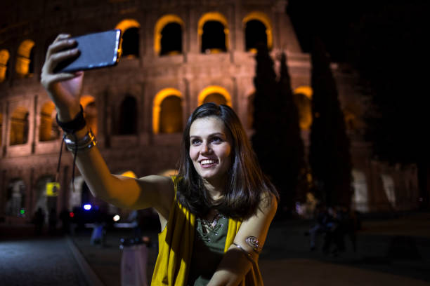 istock Smiling tourist taking night selfie in Italy 894087890