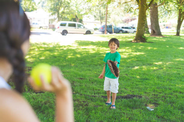 istock Mom and Her Boy Play Catch at the Park 894104004