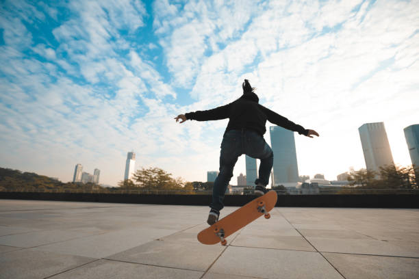 istock female skateboarder jumping on city with skateboard 894129280