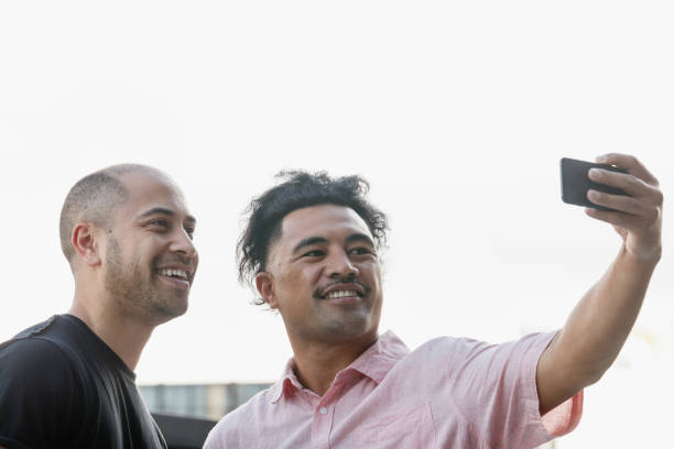 Dois homens tomar um selfie usando um telefone celular - foto de acervo