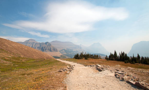 ukryty szlak turystyczny jeziora na przełęczy logan pod cirrus i chmury soczewkowe podczas pożarów upadku w 2017 roku w parku narodowym glacier w montanie w stanach zjednoczonych - lake us glacier national park cloudscape cloud zdjęcia i obrazy z banku zdjęć