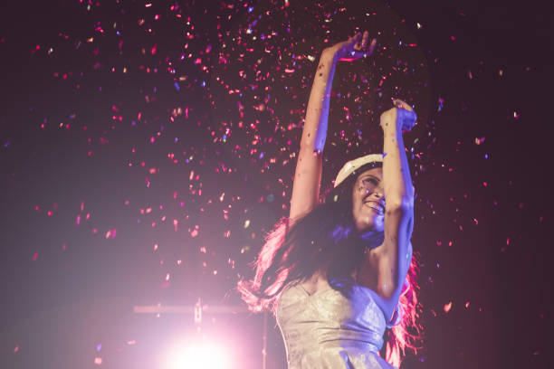 istock Happy woman dancing under confetti at a party 894184048