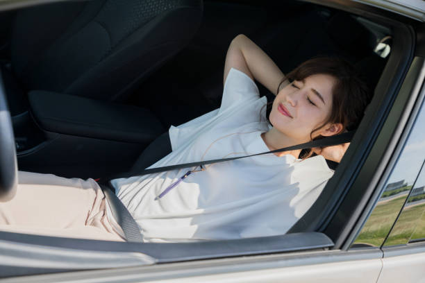 young woman sleeping on drivers seat of vehicle. young woman sleeping on drivers seat of vehicle. drivers seat stock pictures, royalty-free photos & images