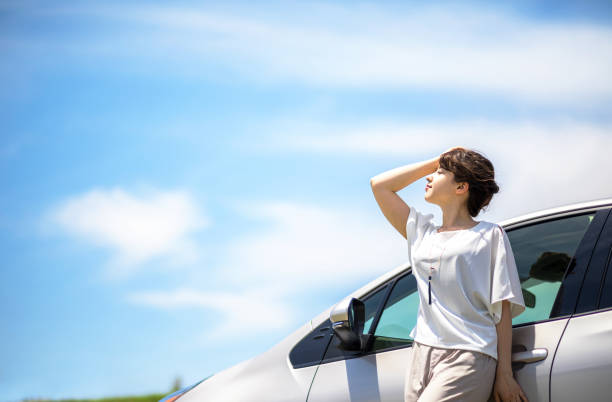 istock woman driver and vehicle under the blue sky. 894186700
