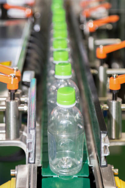 istock plastic bottle on factory line machine in the factory, selective focus. 894186826