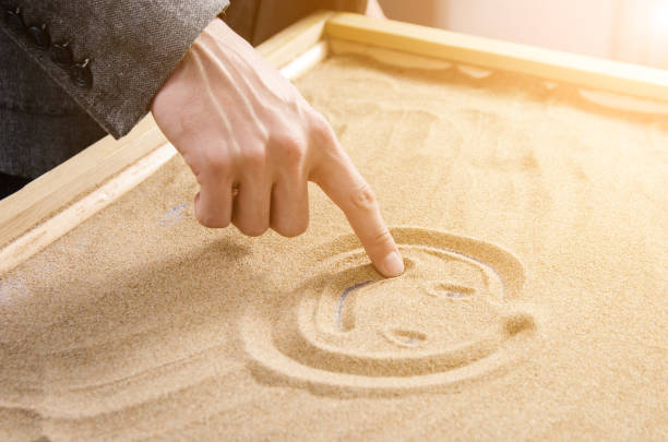istock a man drawing by his finger a smiling smiley. toned. 894189142