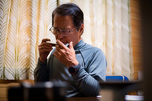 I photographed a senior Japanese man who blows harmonica while taking a break in work in Okinawa