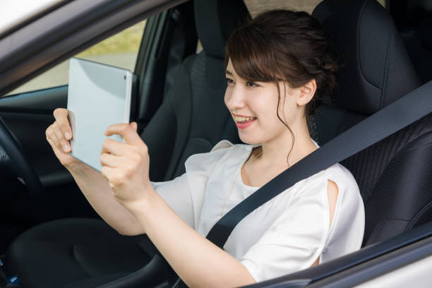 istock young woman using tablet PC on assistant seat of motor vehicle. 894227542