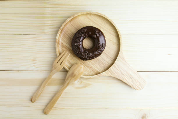 Chocolate Donuts on wooden plate on wooden background