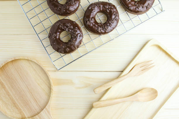 Chocolate Donuts and wooden plate on wooden background