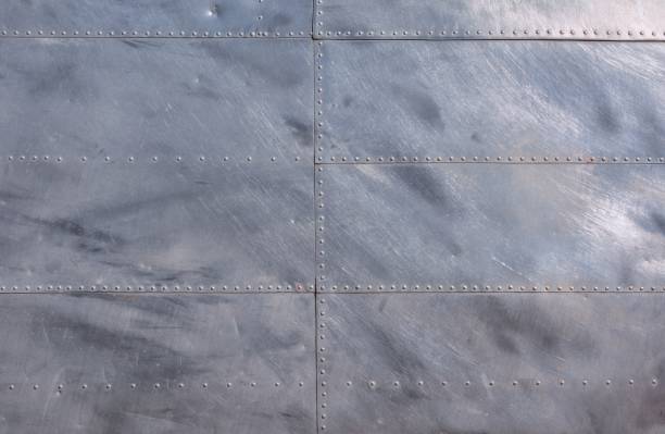 Airplane fuselage silver metal texture. Airplane fuselage silver metal texture with rivets. Useful as background for design works. riveted metal texture stock pictures, royalty-free photos & images