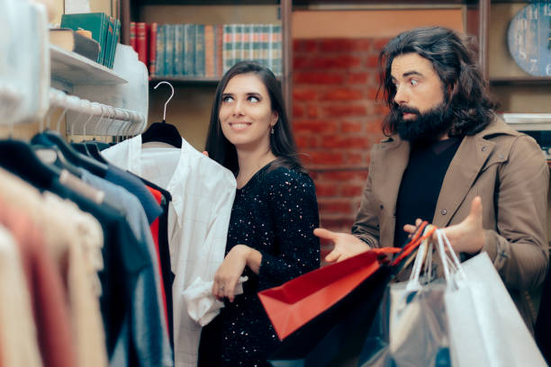 casal shopping para comprar roupas em uma loja de moda - christmas emotional stress shopping holiday - fotografias e filmes do acervo