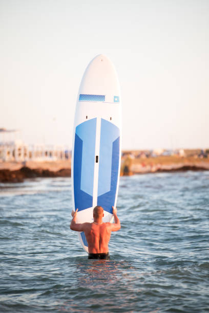 istock A man stands with a SUP on the seafront 894305552