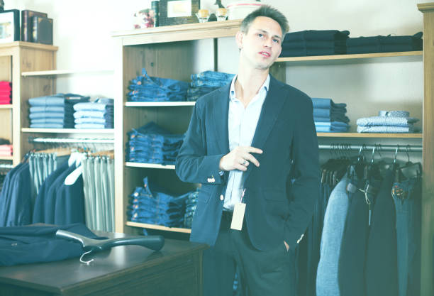 istock Shopper is trying on new dark blue jacket 894312488