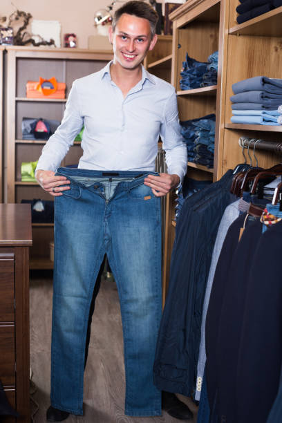 istock Young man is choosing on new jeans 894312492
