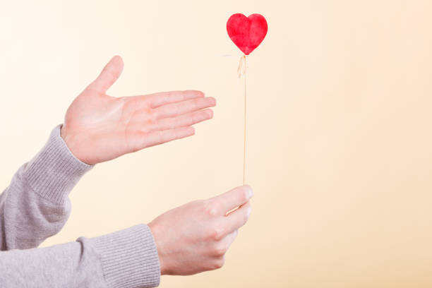 istock Male hand with little heart on stick. 894315370