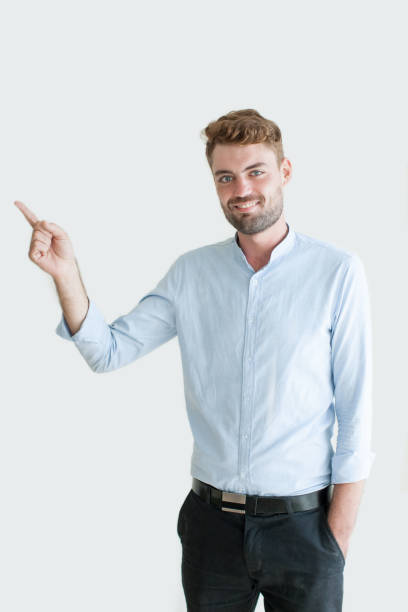istock Portrait of Smiling Young Man Pointing Finger Aside 894315640