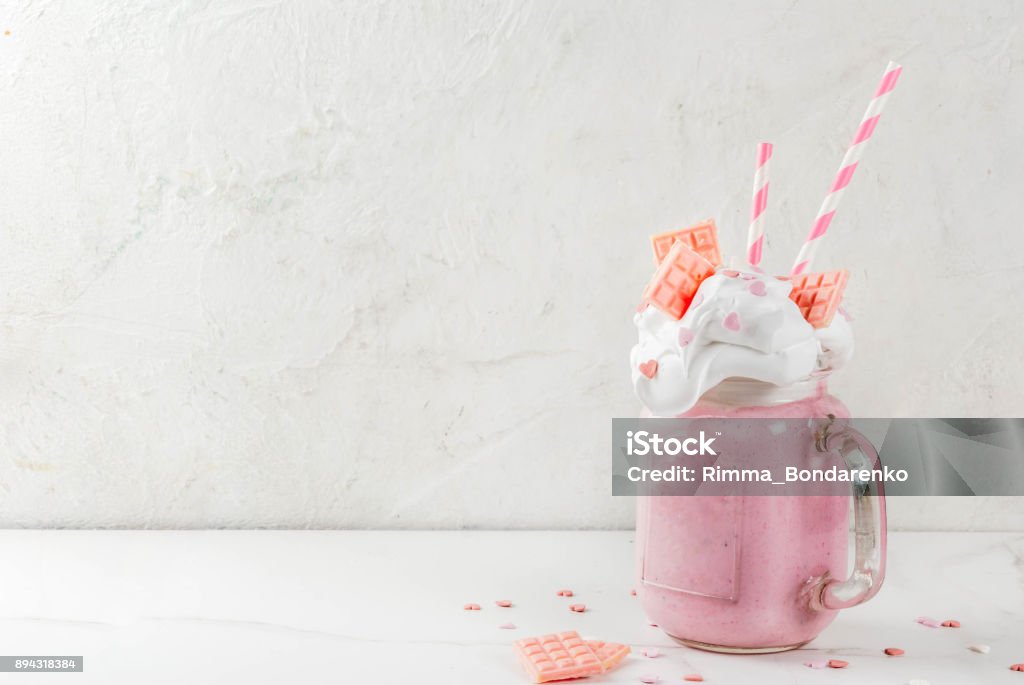 Milkshake for Valentine's day Crazy shake, romantic milkshake for Valentine's day with strawberry, white chocolate and sugar candy hearts, on white background, copy space Milkshake Stock Photo