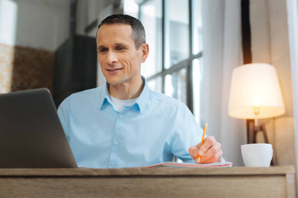 istock Positive delighted worker looking at his laptop 894334744