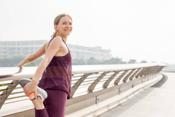 istock Happy Girl Holding and Stretching Leg on Bridge 894336962