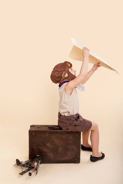 istock Young girl playing with vintage paper airplane 894337556