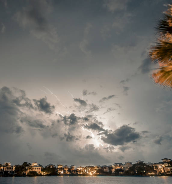 Massive Hurrican Harvey Storm clouds with lightning at night. A spinoff band of storms from Hurricane Harvey produces an impressive light show at night with large lightning revealing turbulent clouds as they pass over a small beachside community and a lake in the foreground. hurrican stock pictures, royalty-free photos & images
