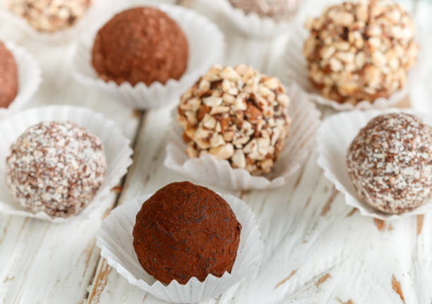 istock Assorted dark chocolate truffles with cocoa powder, coconut and chopped almonds closeup. Homemade candy. Selective focus 894341826