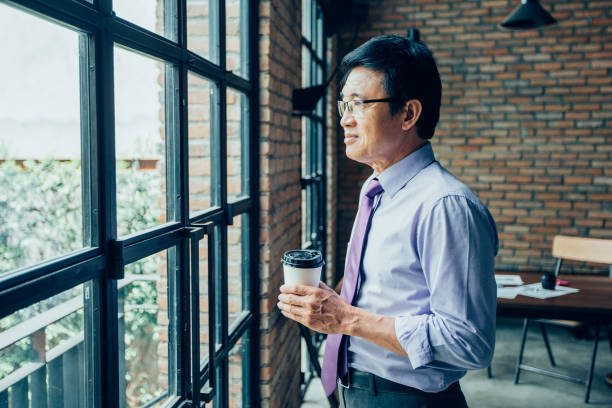 istock Thoughtful Senior Man at Window in Loft Cafe 894344690