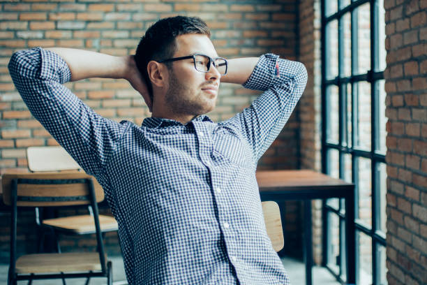 istock Young Man Relaxing at Window in Loft Cafe 894344770