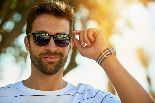 Portrait of a handsome young man wearing sunglasses on a summer’s day outdoors