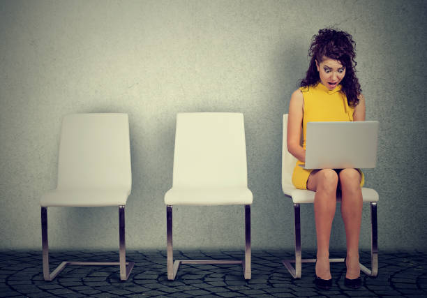 istock Terrified woman watching laptop on chair 894361372