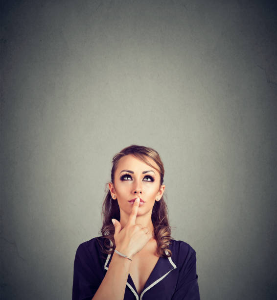 istock Thoughtful woman looking up on gray 894373018