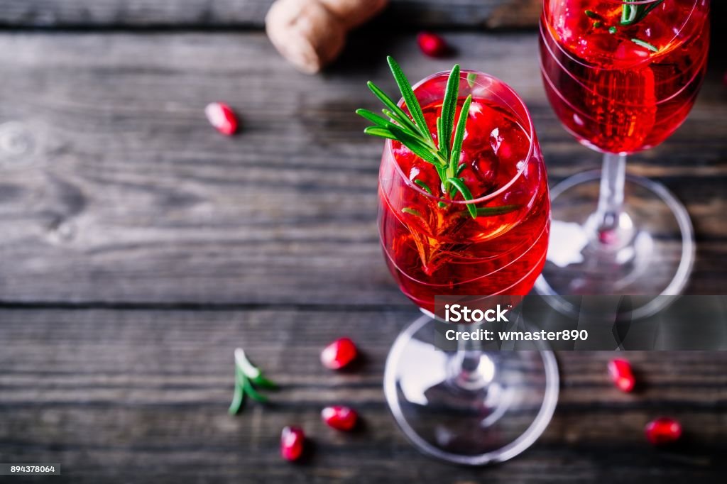 Pomegranate champagne mimosa cocktail with rosemary Pomegranate champagne mimosa cocktail with rosemary in glasses on wooden background Pomegranate Stock Photo