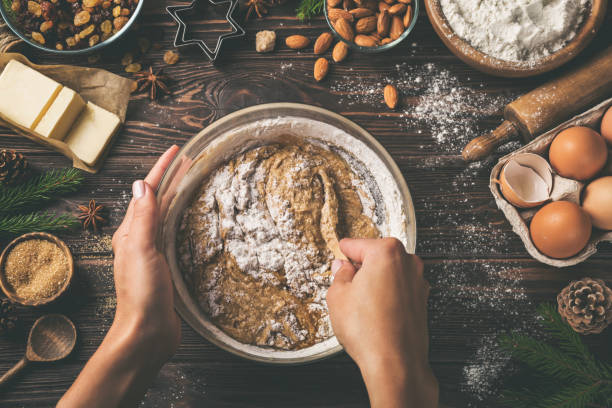istock young woman's hands cooking christmas fruit cake. Wooden table with baking ingredients. 894378214