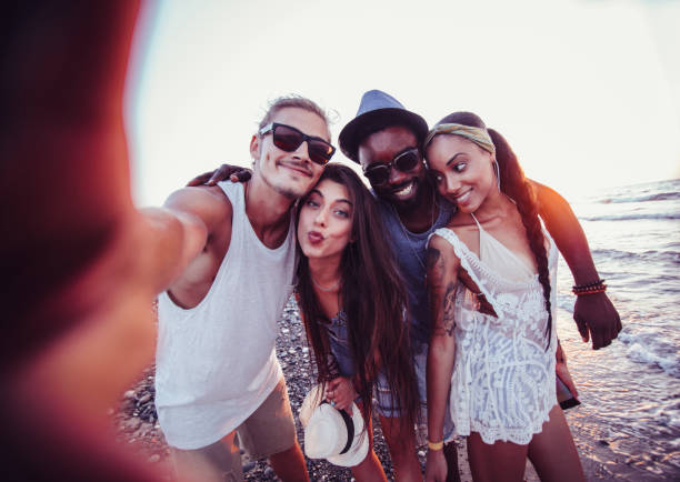istock Young multi-ethnic hipster tourist friends taking selfies on beach 894392594