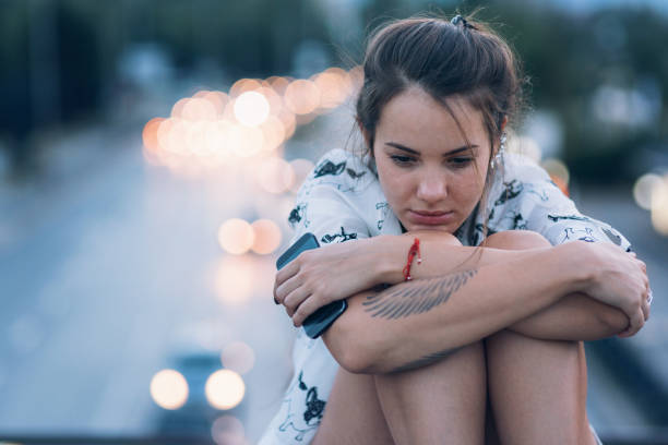 istock Depressed woman sitting on the bridge parapet 894392994