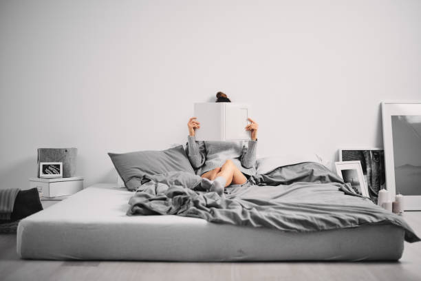istock Woman sitting on bed in the morning 894400158