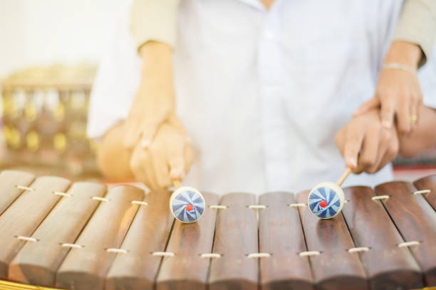 istock Beautiful Asian Teacher teaching students to practice Thai instruments 894405812