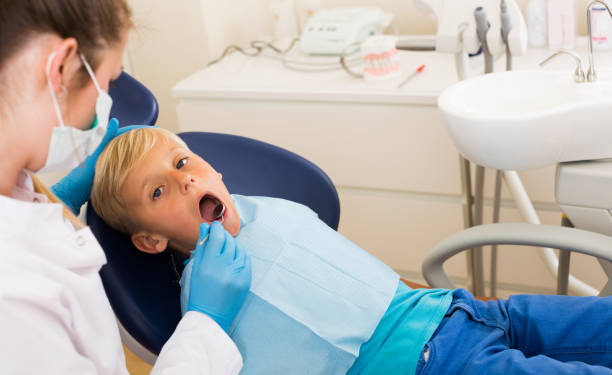 istock Stomatologist in uniform is taking a view of a young child 894406448