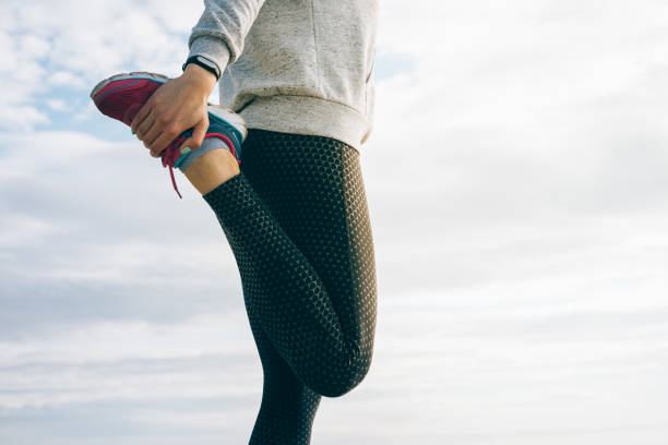 Athletic woman in sportswear doing stretching legs